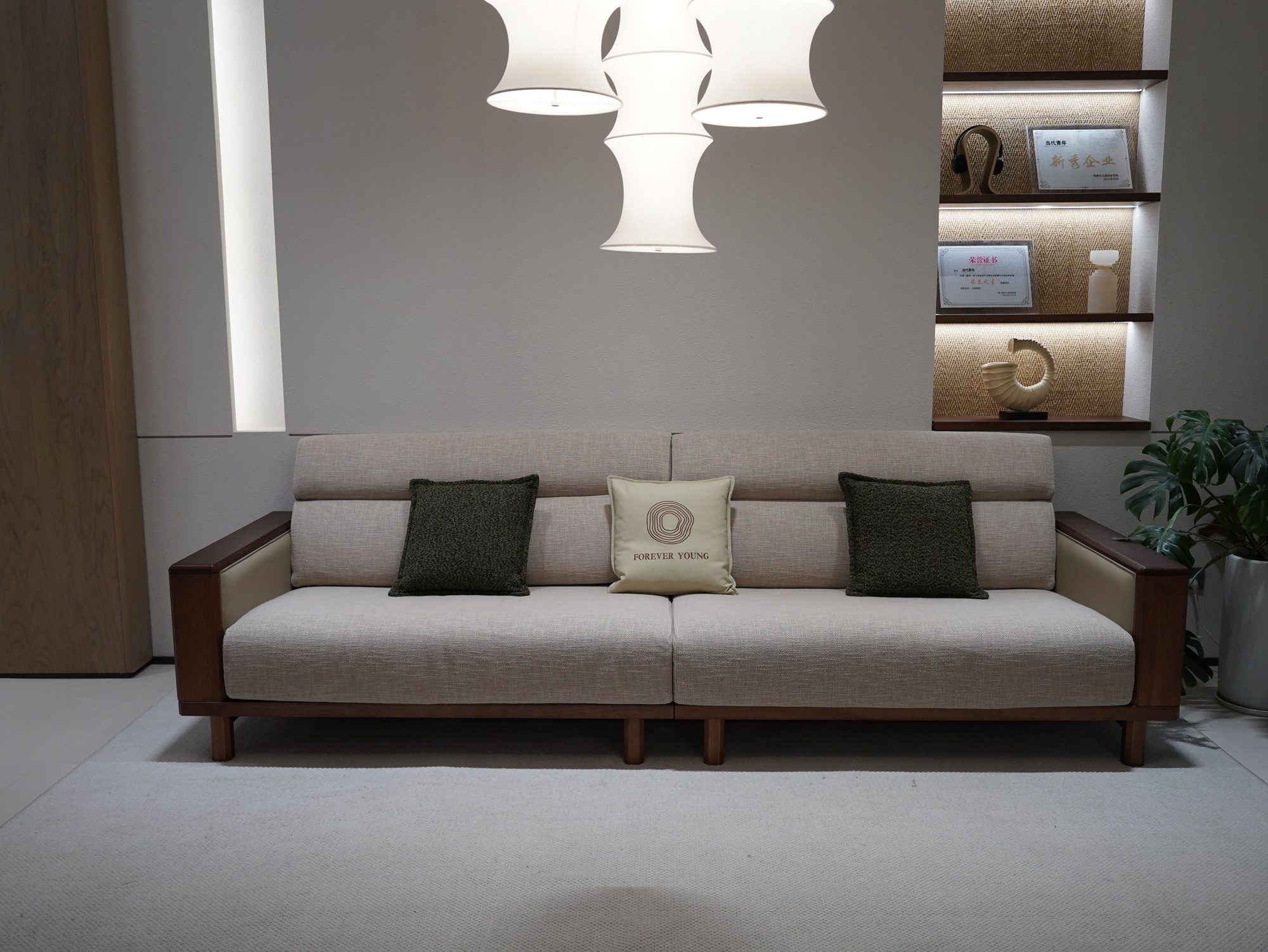 The Form Sofa: a low, wide sofa in oatmeal upholstery with a dark timber frame