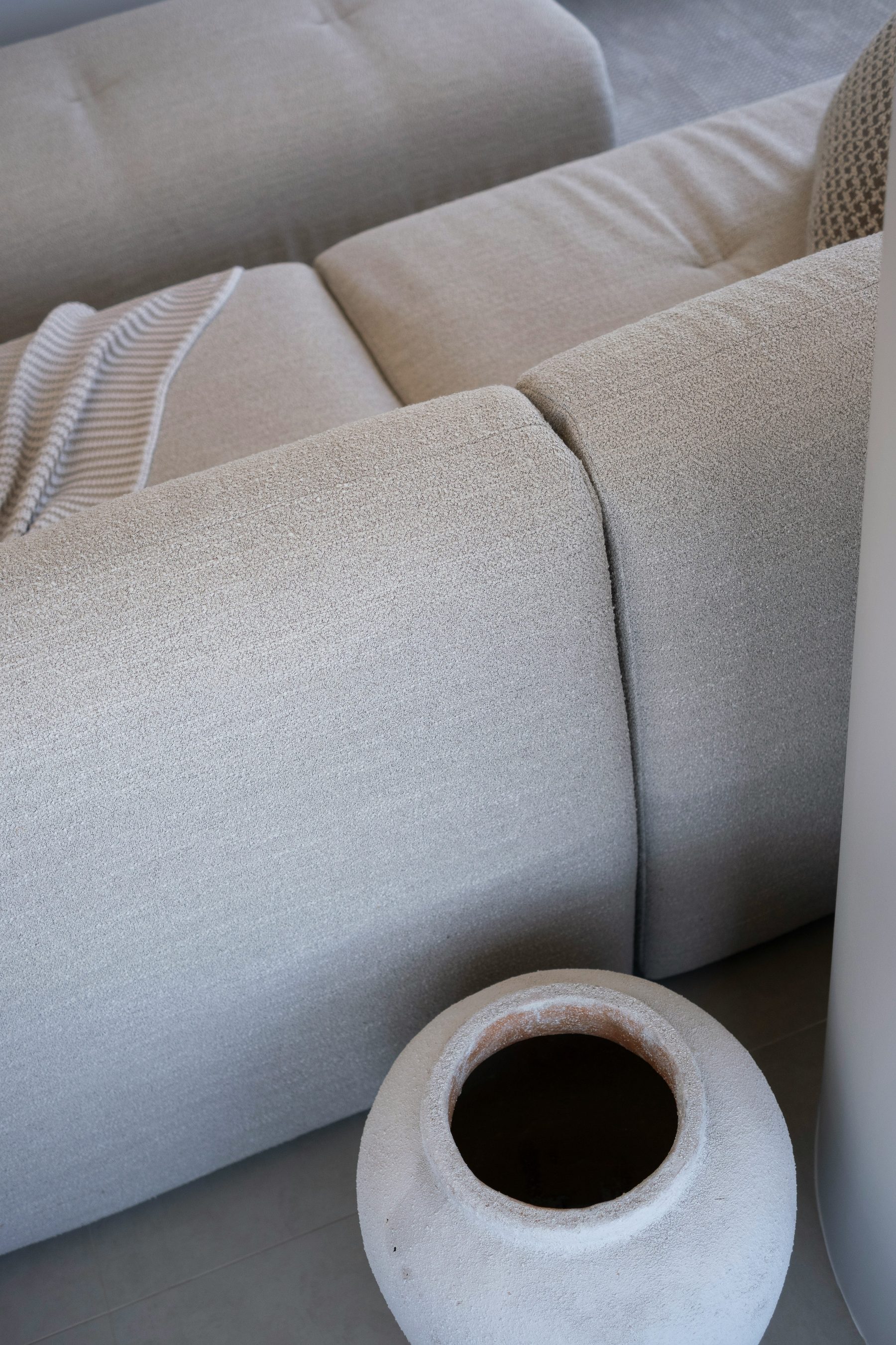 Close-up of woven linen upholstery and a soft knitted throw
