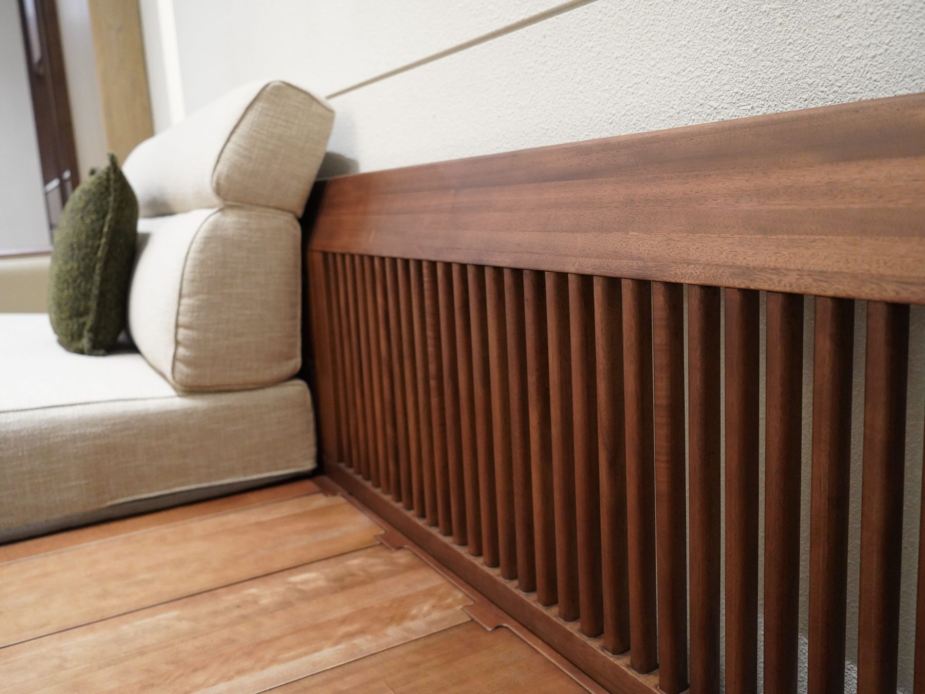 A slatted timber panel beside a cream cushioned seat